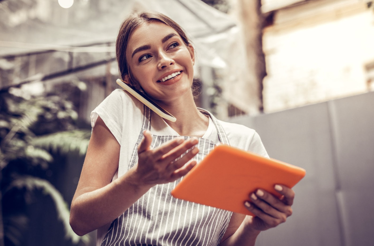 Woman talking on phone and holding an ipad